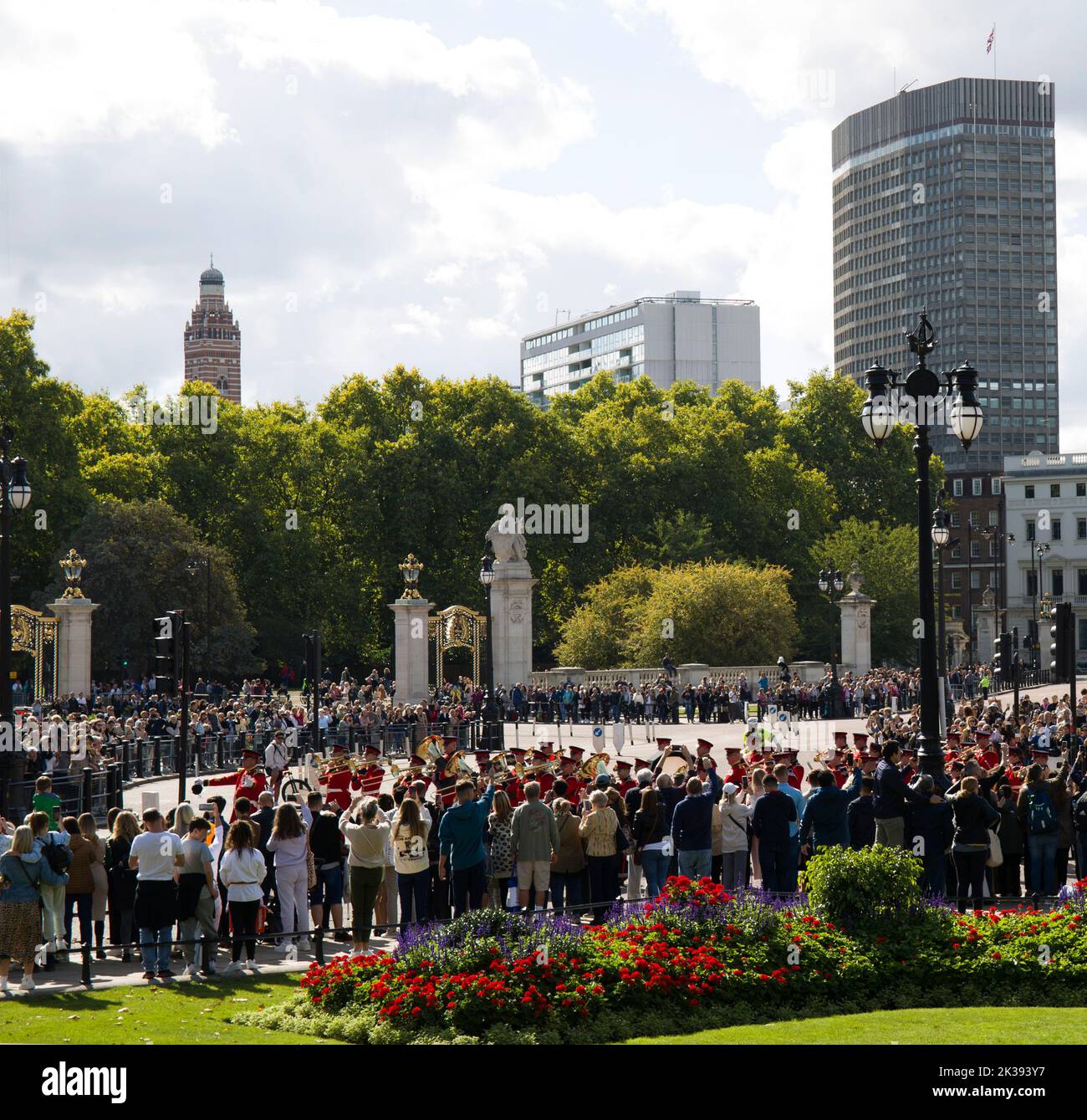 Des foules de touristes et de touristes qui regardent la bande des gardes en marchant Queen Victoria Monument et Buckingham Palace Londres Banque D'Images