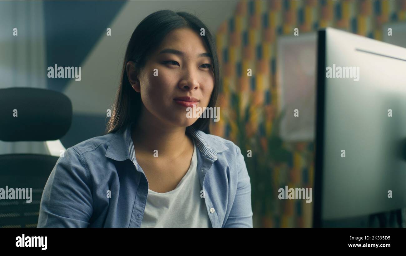 Femme asiatique assise à la table au bureau à domicile et travaillant à distance sur un ordinateur personnel ou naviguant sur Internet en temps libre Banque D'Images