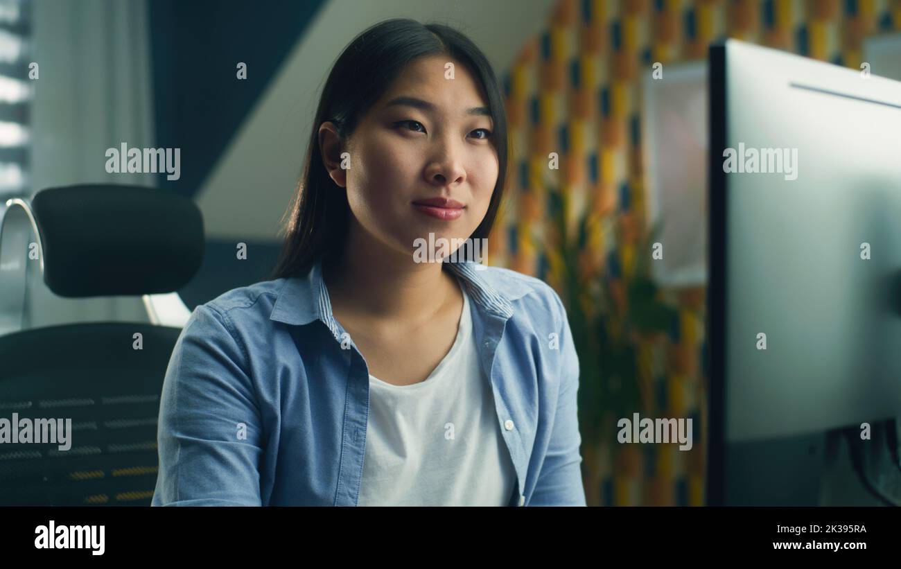 Femme asiatique assise à la table au bureau à domicile et travaillant à distance sur un ordinateur personnel ou naviguant sur Internet en temps libre Banque D'Images