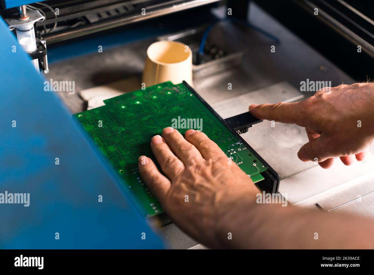 Ingénieur mâle européen lors du montage manuel CMS. Humain contre machine. Concept de technologie moderne. Processus de réparation de PCB. Photo de haute qualité Banque D'Images