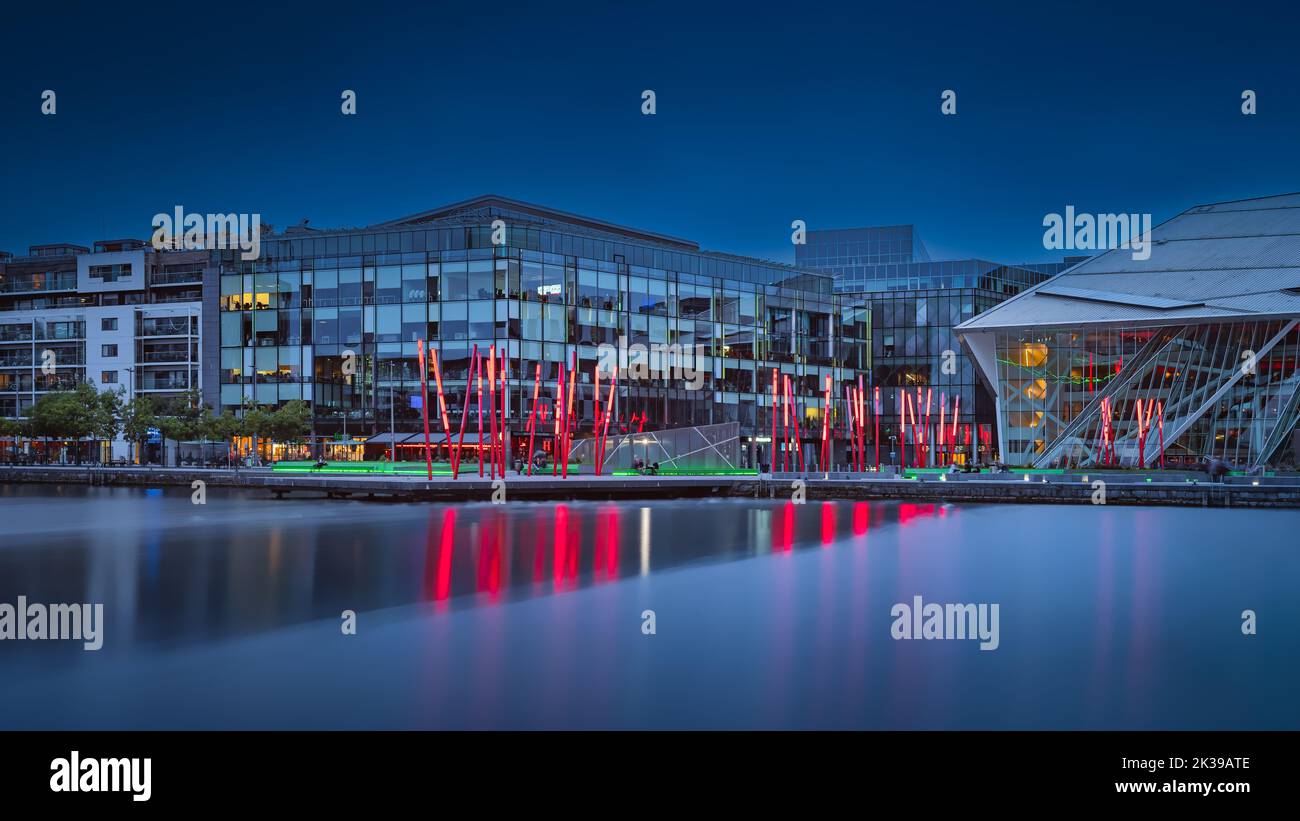 Dublin, Irlande, août 2019 Grand Canal Square dans les docklands avec théâtre, bâtons rouges, magasins et bâtiments la nuit ou heure bleue Banque D'Images