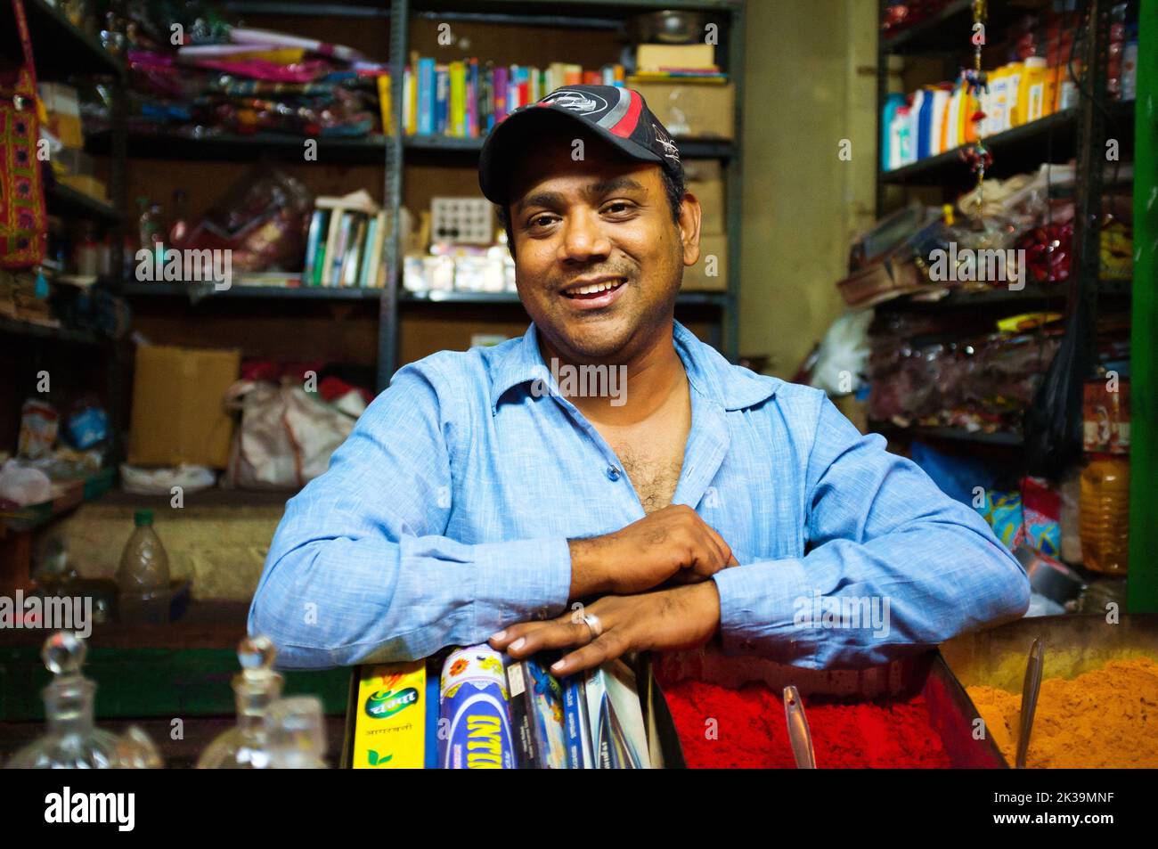 Homme indien souriant vendant de la poudre tikka colorée au marché de Devaraja Banque D'Images