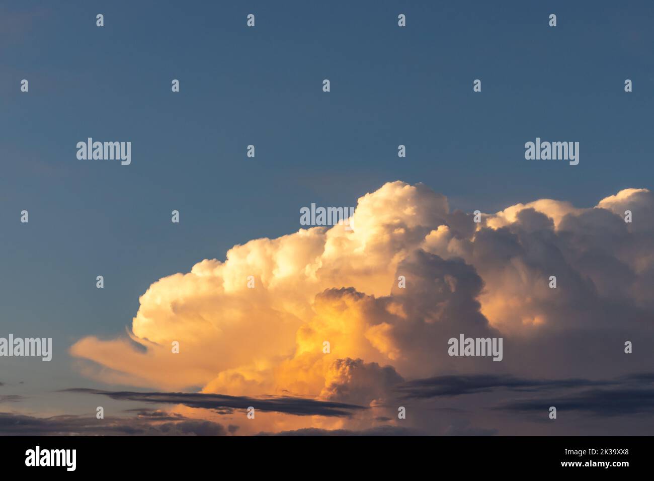 Lumière vive réfléchie sur un nuage d'orage élevé dans le ciel. Différentes formes de nuages au soleil du soir. Magnifique paysage de nuages vibrants. Banque D'Images