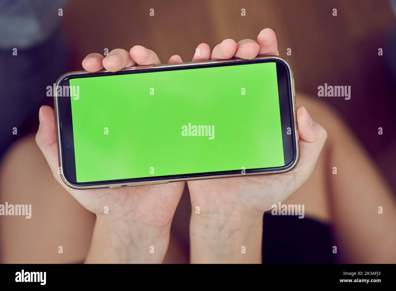 Gros plan des mains des enfants à l'aide d'un téléphone avec écran vert. Une petite fille est assise sur le sol et tient un smartphone avec une clé de couleur. Photo de haute qualité Banque D'Images Gros plan des mains des enfants à l'aide d'un téléphone avec écran vert. Une petite fille est assise sur le sol et tient un smartphone avec une clé de couleur. Photo de haute qualité Banque D'Images