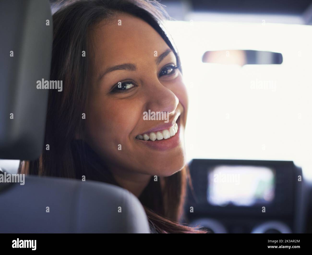 Si nous devions prendre la route. Portrait d'une jeune femme assise dans une voiture en regardant derrière son épaule. Banque D'Images