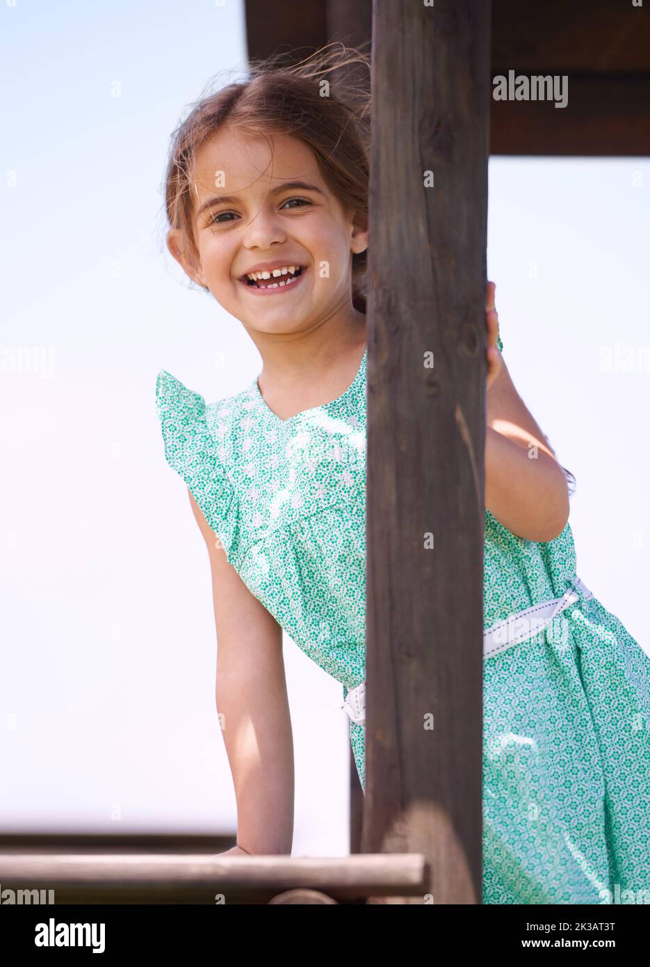 Elle adore jouer dehors. Portrait d'une petite fille jouant sur un gymnase de la jungle un jour ensoleillé. Banque D'Images