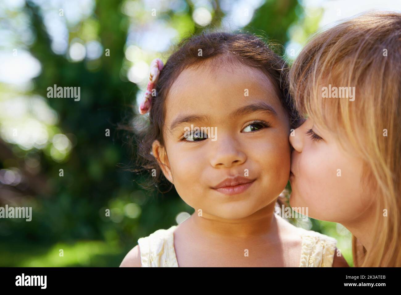 Le meilleur des amis. Une petite fille embrassant son ami sur la joue. Banque D'Images