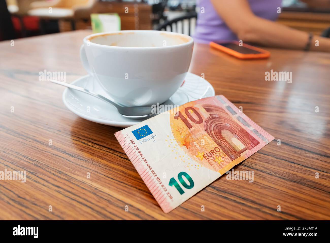 Le client a laissé un généreux pourboire après le petit déjeuner dans le café. Un billet de dix euros sur une table Banque D'Images