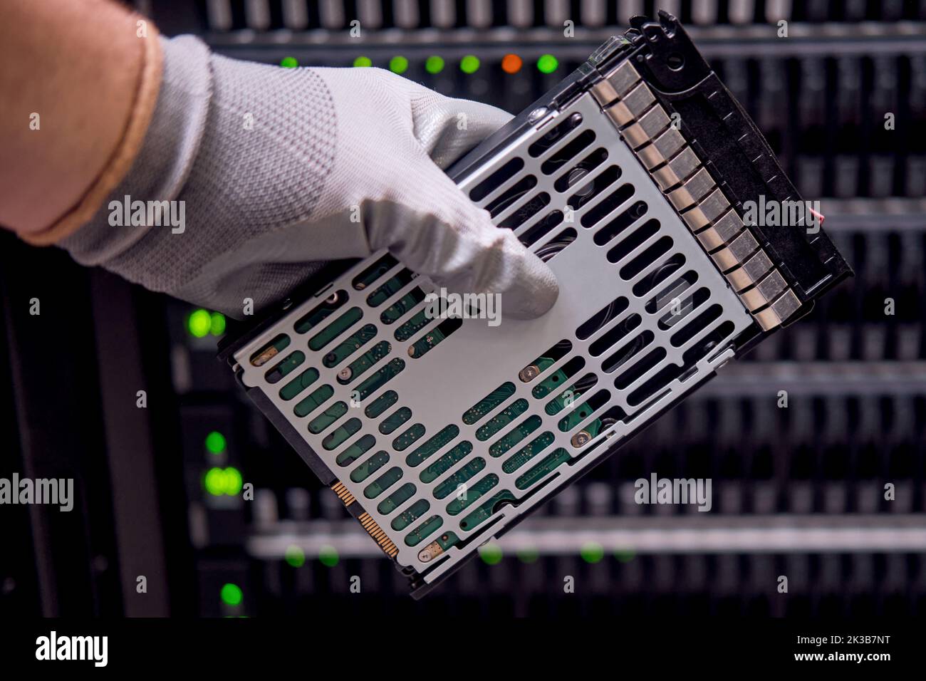 Un disque dur pour un raid entre les mains d'un homme sur un serveur de stockage de données, gros plan Banque D'Images