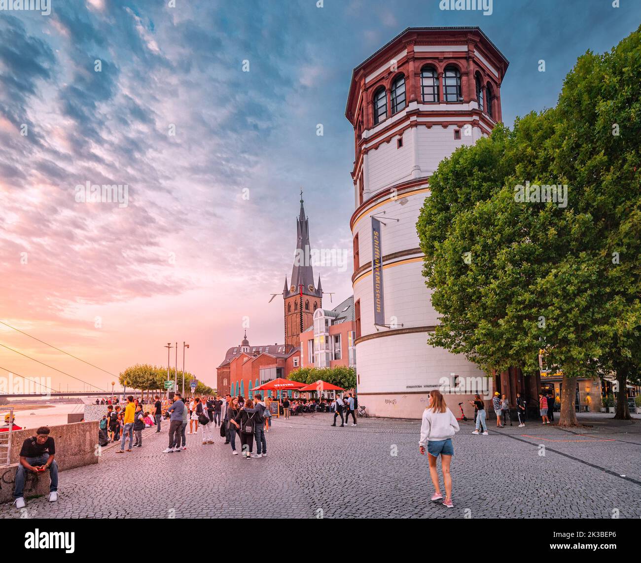 22 juillet 2022, Düsseldorf, Allemagne : personnes marchant sur la promenade et admirant le coucher du soleil sur la vieille ville de Düsseldorf Tours à Altstadt. Voyage et vis Banque D'Images