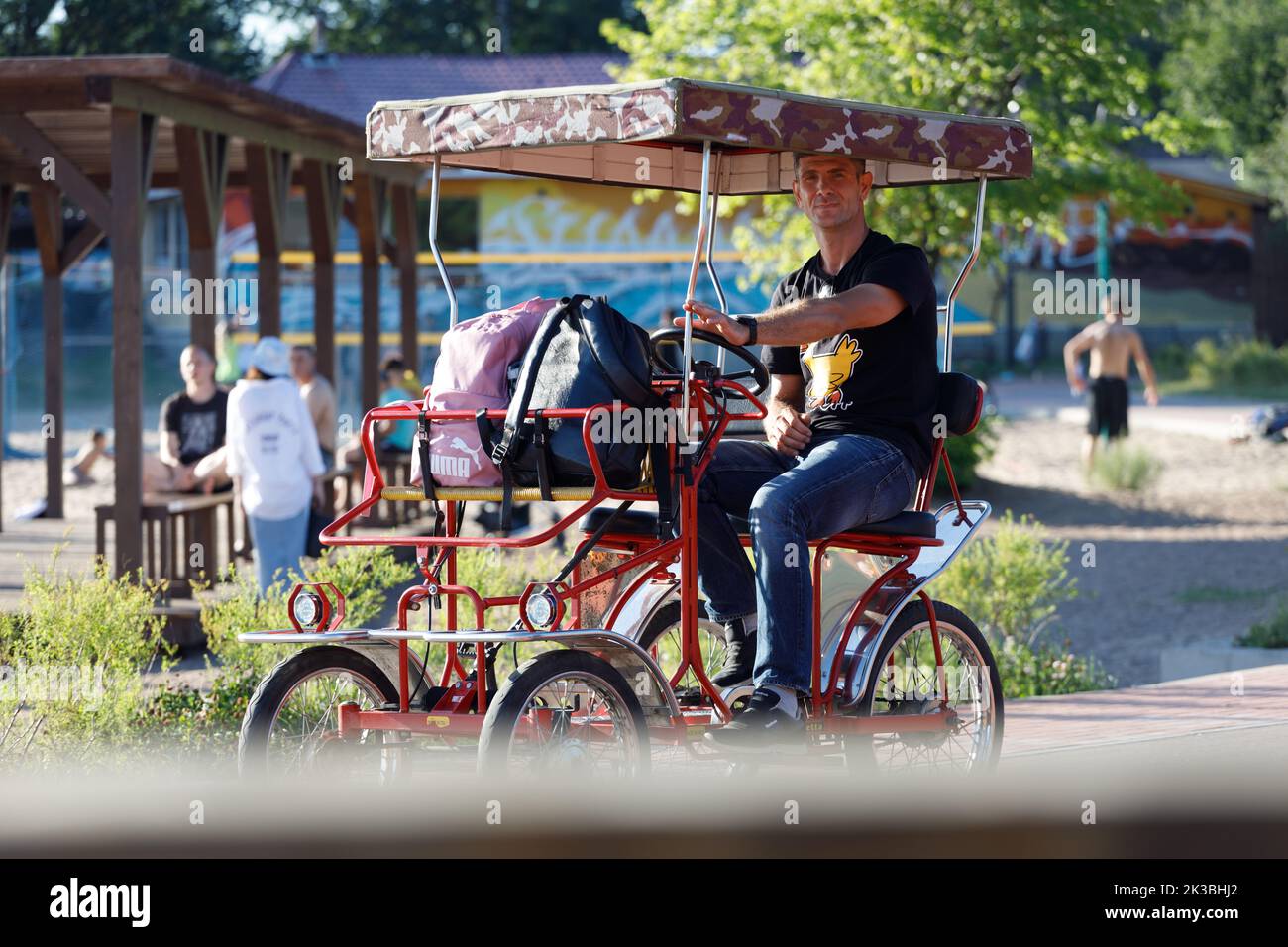 Russie Vyborg 08.08.2021 Un homme fait un vélo à quatre roues dans un parc en été. Photo de haute qualité Banque D'Images