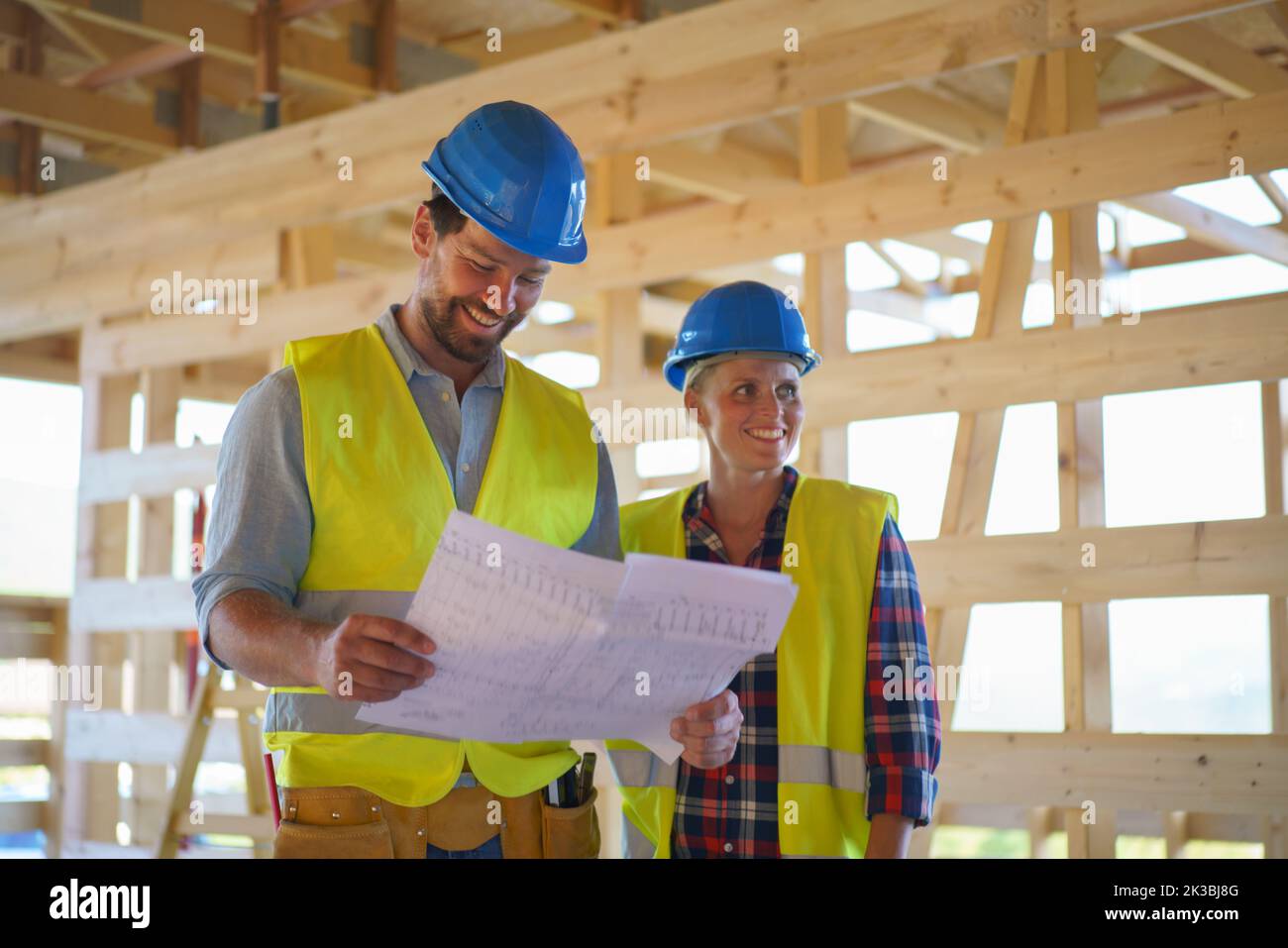 Les ingénieurs de construction ou les architectes avec des plans-plans vérifiant le site de construction écologique de la maison de cadre en bois Banque D'Images