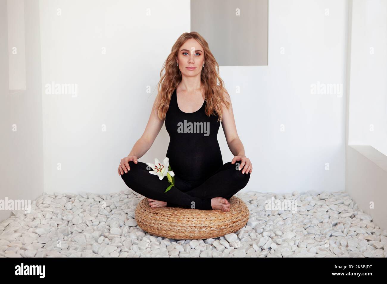 Belle femme enceinte Sporty assise sur le sol en position lotus méditant ou faisant des exercices pilates dans le spa. Yoga, fitness Banque D'Images