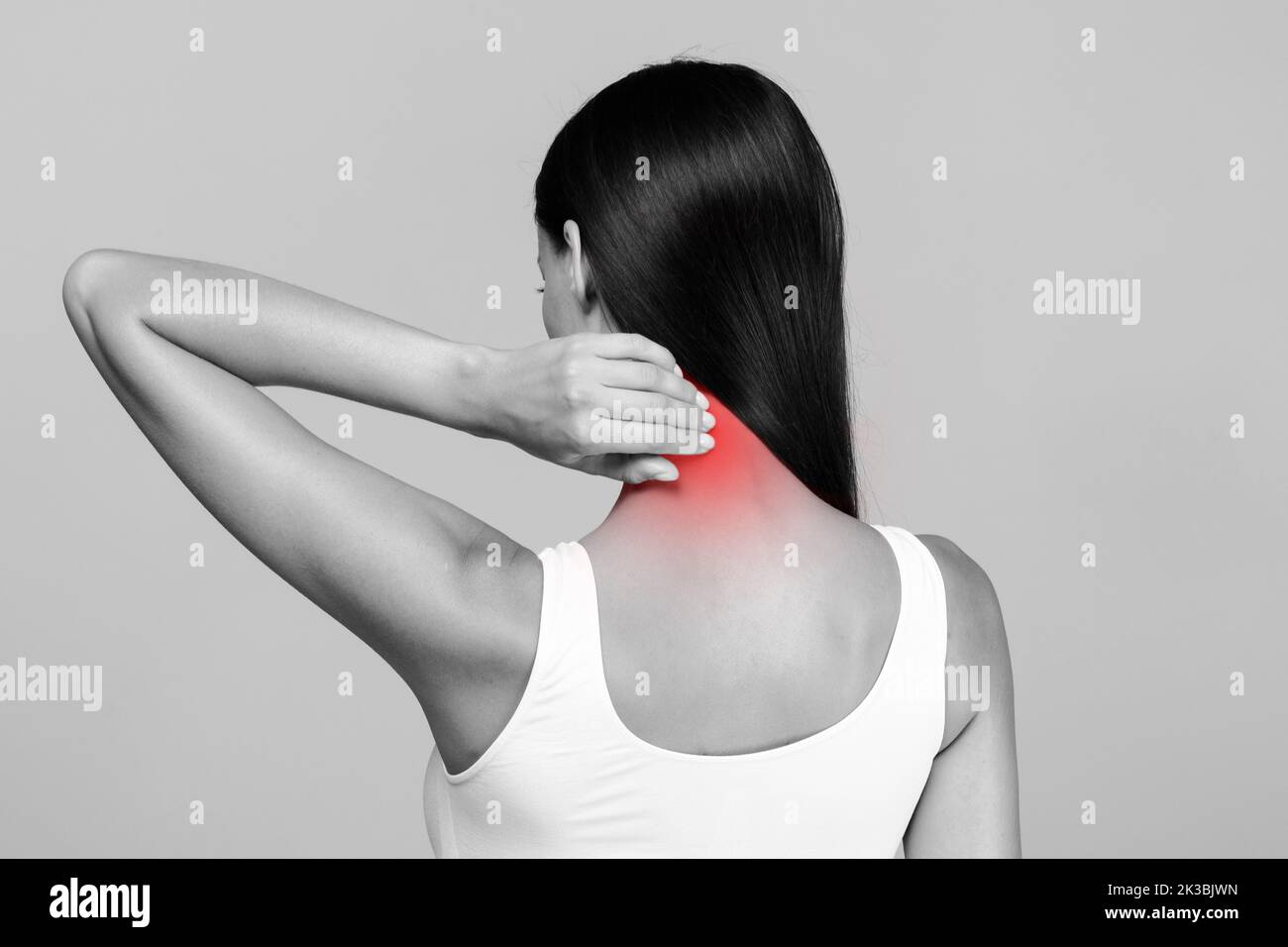 Douleur au cou stress et tension musculaires. Femme méconnaissable en haut massant rouge mal de cou, vue arrière, photo noir et blanc Banque D'Images