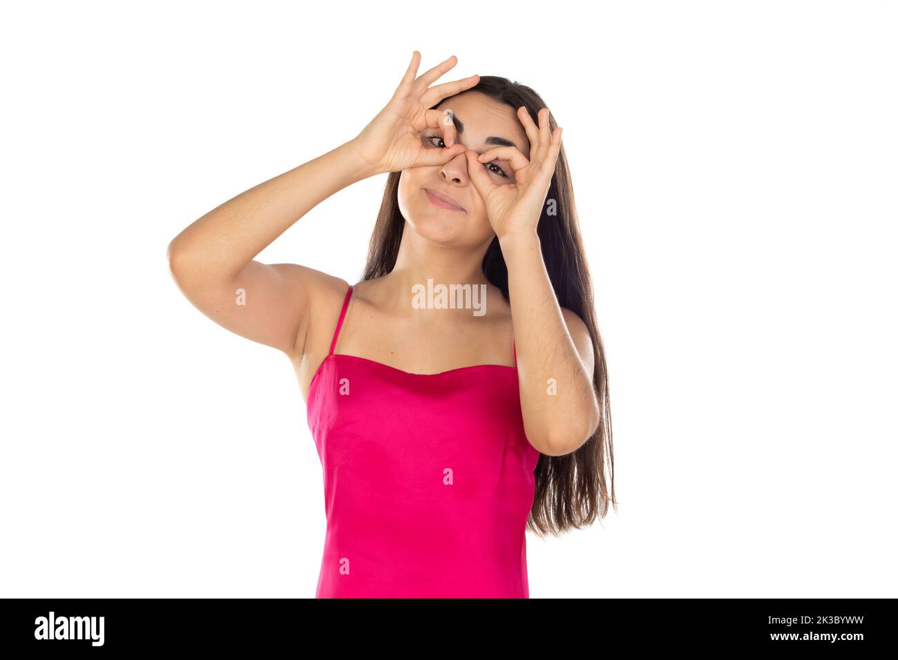 Jeune femme brune regardant à travers ses doigts comme ils étaient des lunettes isolées sur un fond blanc Banque D'Images