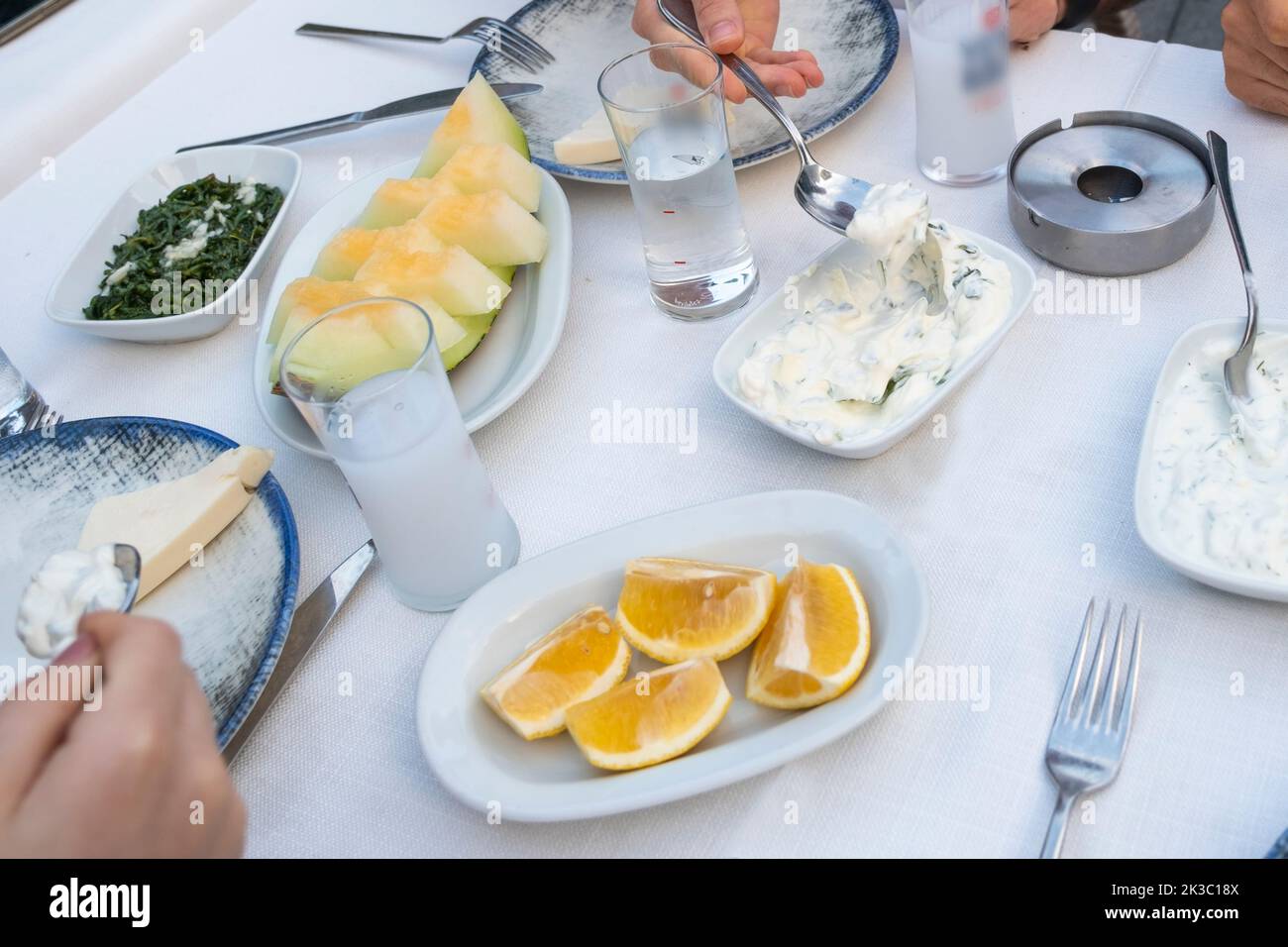 Table de raki turque avec melon, citron et hors-d'œuvre, alcool turc traditionnel connu sous le nom de Rakı, détendez-vous entre amis au restaurant, dîner et idée de repas Banque D'Images