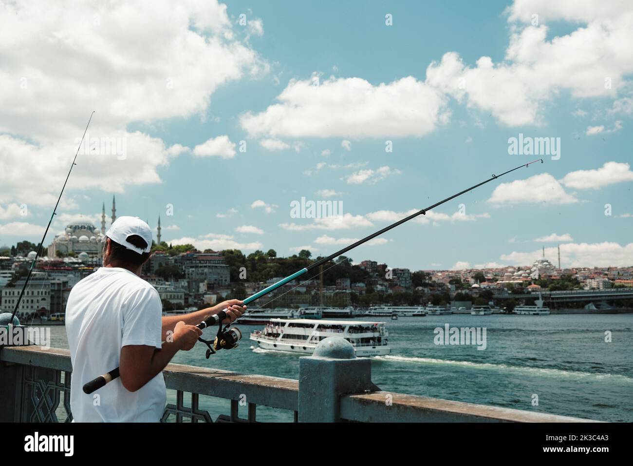 Pêcheur sur le pont Eminönü Galata, Turquie Istanbul concept de tourisme, grand angle, temps nuageux, homme d'âge moyen en blanc, passe-temps et loisirs Banque D'Images