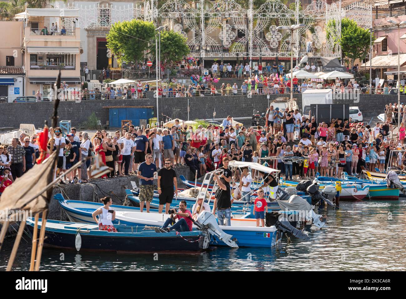 Les foules se rassemblent pour assister au festival annuel de 'U Pisci a mari' dans le village sicilien d'ACI Trezza, près de Catane. Cela a lieu autour de la Fête de la Nativité de Saint Jean-Baptiste, à la fin du mois de juin. Il représente une expédition traditionnelle de pêche de l'espadon, qui avait lieu dans le détroit de Messine. La partie de l'espadon est jouée par un nageur, qui est pris à plusieurs reprises par les pêcheurs, sectionné dans le sang, mais parvient d'une manière ou d'une autre à s'échapper. Finalement, l'espadon parvient à renverser le bateau. Banque D'Images