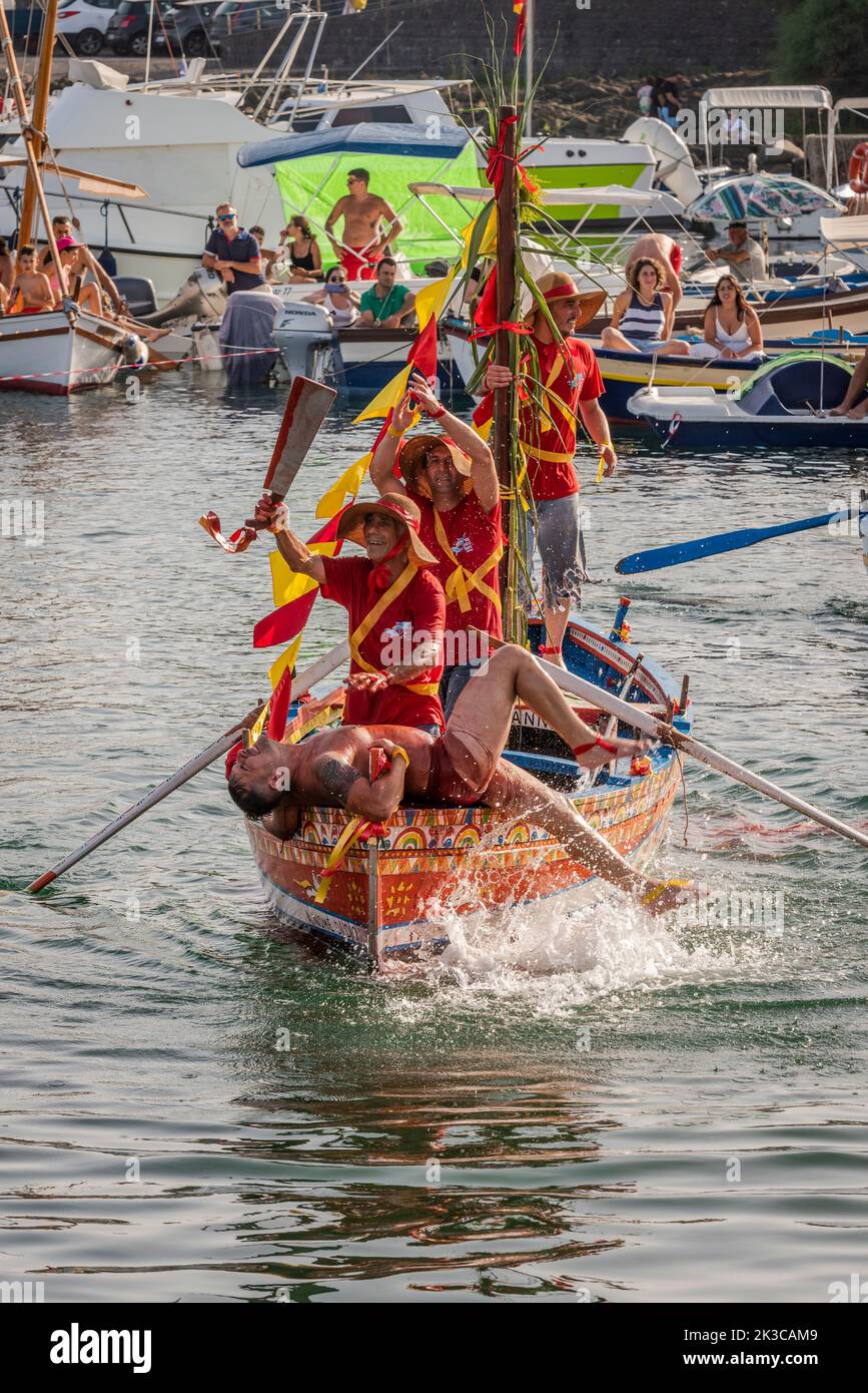 Le festival annuel de 'U Pisci a mari' dans le village sicilien d'ACI Trezza, près de Catane. Cela a lieu autour de la Fête de la Nativité de Saint Jean-Baptiste, à la fin du mois de juin. Il représente une expédition traditionnelle de pêche de l'espadon, qui avait lieu dans le détroit de Messine. La partie de l'espadon est jouée par un nageur, qui est pris à plusieurs reprises par les pêcheurs, sectionné dans le sang, mais parvient d'une manière ou d'une autre à s'échapper. Finalement, l'espadon parvient à renverser le bateau. Banque D'Images