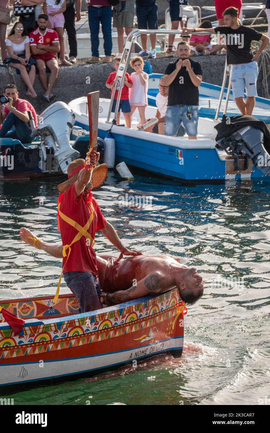 Le festival annuel de 'U Pisci a mari' dans le village sicilien d'ACI Trezza, près de Catane. Cela a lieu autour de la Fête de la Nativité de Saint Jean-Baptiste, à la fin du mois de juin. Il représente une expédition traditionnelle de pêche de l'espadon, qui avait lieu dans le détroit de Messine. La partie de l'espadon est jouée par un nageur, qui est pris à plusieurs reprises par les pêcheurs, sectionné dans le sang, mais parvient d'une manière ou d'une autre à s'échapper. Finalement, l'espadon parvient à renverser le bateau. Banque D'Images