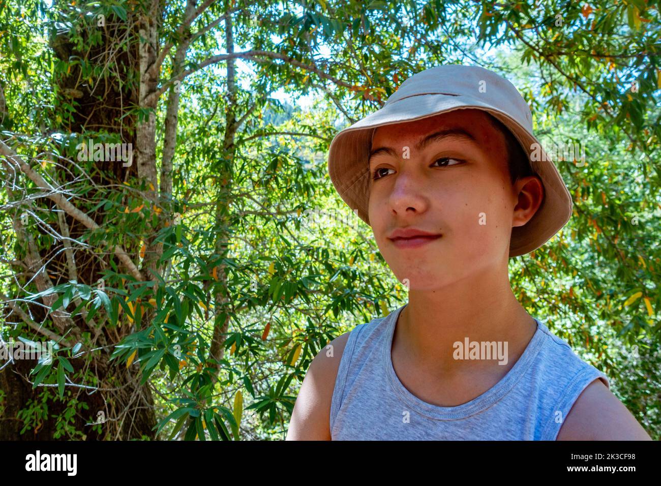 Portrait d'un adolescent portant un chapeau de soleil dans les bois. Banque D'Images