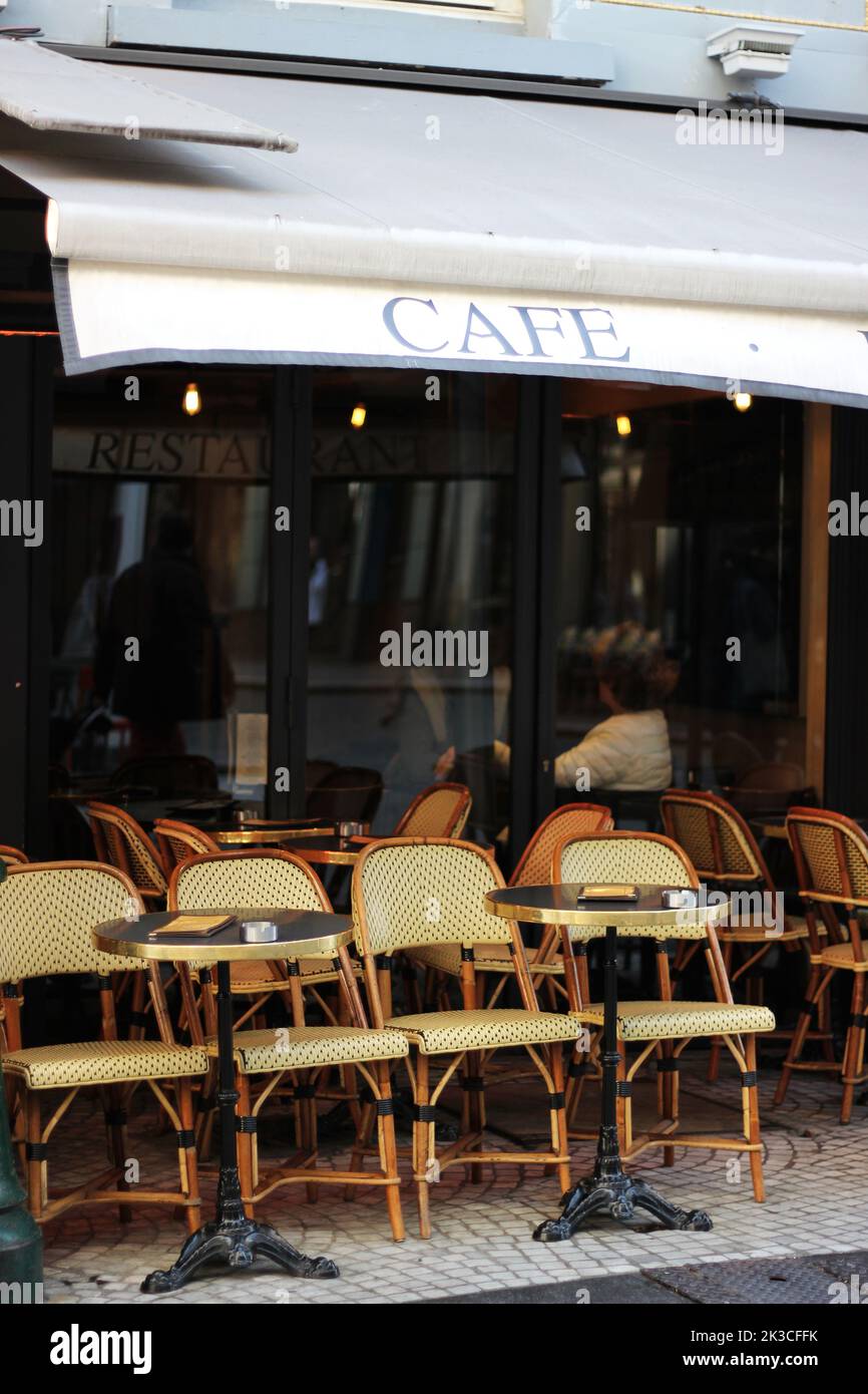Paris, France. Tables de terrasse de café vides avec chaises en osier. Café français classique. Banque D'Images