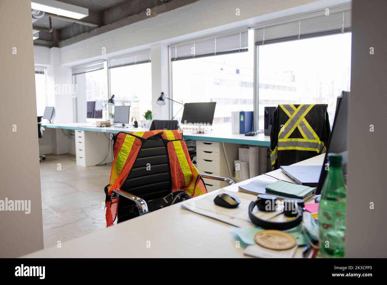 Gilet réfléchissant sur chaise au bureau dans le bureau ouvert Banque D'Images