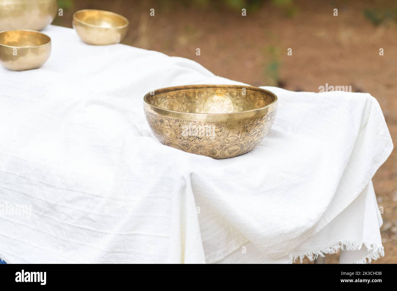 Grand bol de chant tibétain près d'un pied pendant le massage de guérison sonore avec le Bouddha Népal bol de chant extérieur, foyer sélectif Banque D'Images