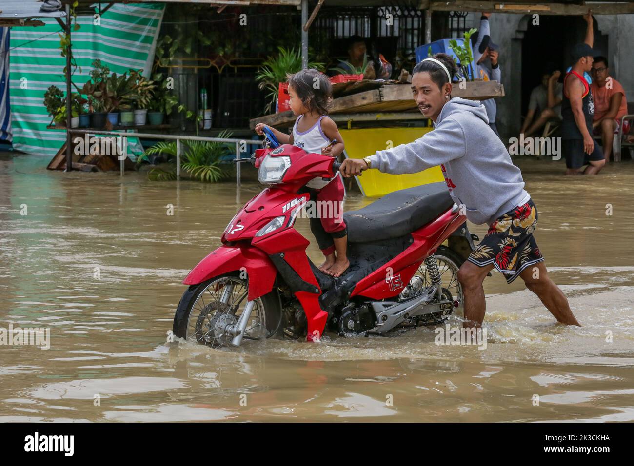 Bulacan, Philippines. 26th septembre 2022. Un homme pousse sa moto avec un enfant à bord par une route inondée dans la province de Bulacan, aux Philippines, le 26 septembre 2022. Le typhon Noru a frappé l'île de Luzon aux Philippines avec de fortes pluies et des vents depuis dimanche après-midi, laissant cinq morts, alors qu'elle s'éloignait du pays d'Asie du Sud-est lundi. Crédit: Rouelle Umali/Xinhua/Alamy Live News Banque D'Images