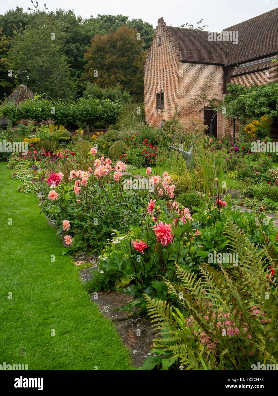 Dahlia borde le jardin en contrebas du Chenies Manor en septembre, l'ancien bâtiment tudor restauré en arrière-plan. Banque D'Images
