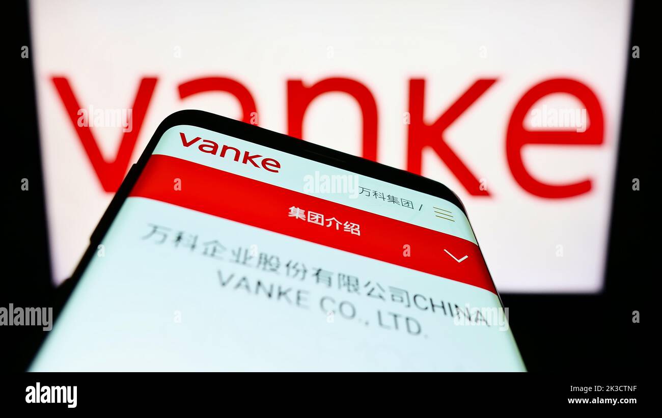 Téléphone mobile avec le site Web de la société immobilière chinoise Vanke Co. Ltd. À l'écran devant le logo d'affaires. Faites la mise au point dans le coin supérieur gauche de l'écran du téléphone. Banque D'Images