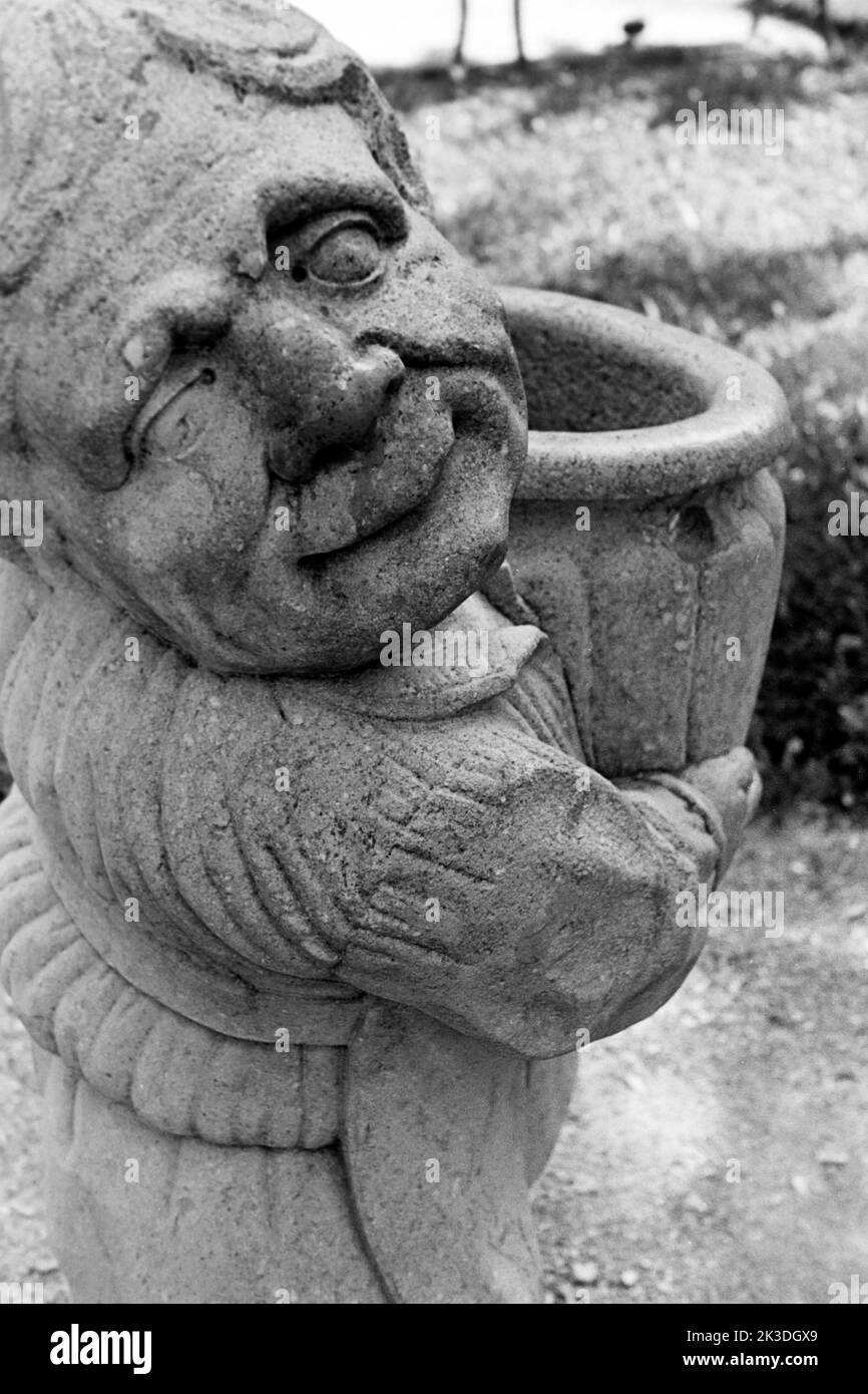 Zwerg mit Gartenvase im Mirabellgarten à Salzbourg, Symbol für den Monat avril, vers 1960. Sculpture d'un nain portant un vase de jardin dans les jardins Mirabell de Salzbourg, symbolique du mois de mars, vers 1960. Banque D'Images