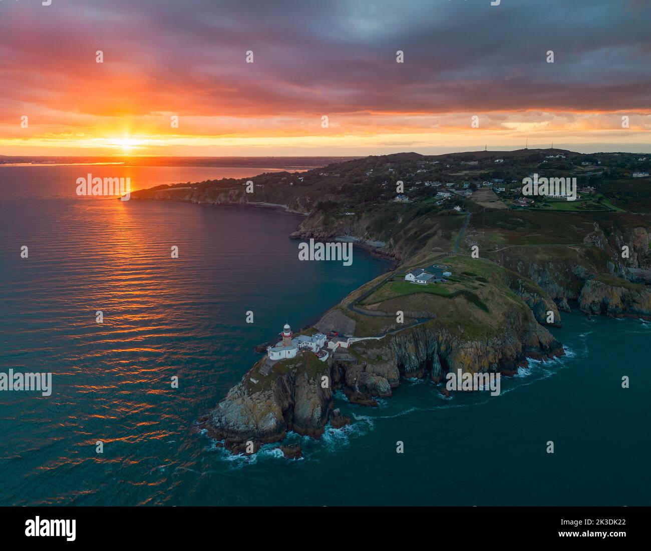 Le soleil se couche à l'ouest d'une vue aérienne sur le phare de BDaily au départ du sommet de Howth Banque D'Images