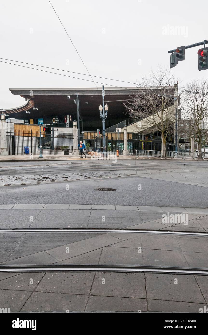 Un homme marche son chien, un Labrador doré en face de Jeld Wen Field, vu de l'autre côté de SW 18th Avenue, à Portland, Oregon. Banque D'Images