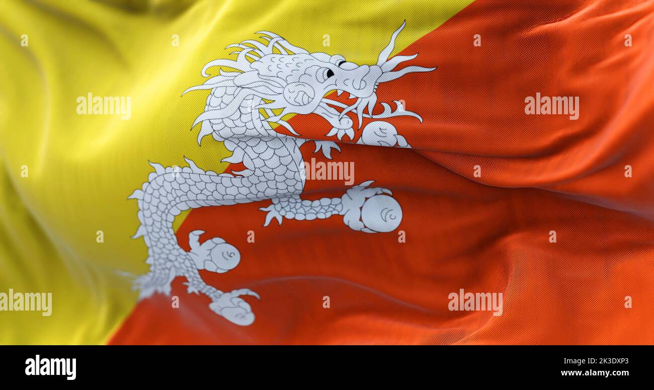 Vue rapprochée du drapeau national du Bhoutan qui agite dans le vent. Le Royaume du Bhoutan est un pays enclavé de l'Himalaya oriental. Tissu texturé Banque D'Images
