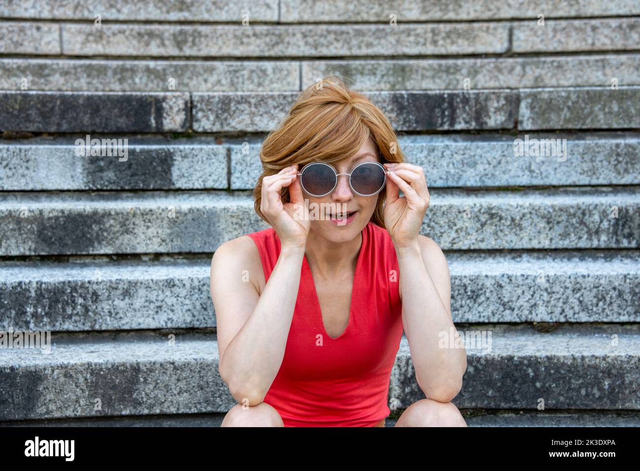 Jeune femme européenne avec des lunettes de soleil et regardant la caméra Banque D'Images