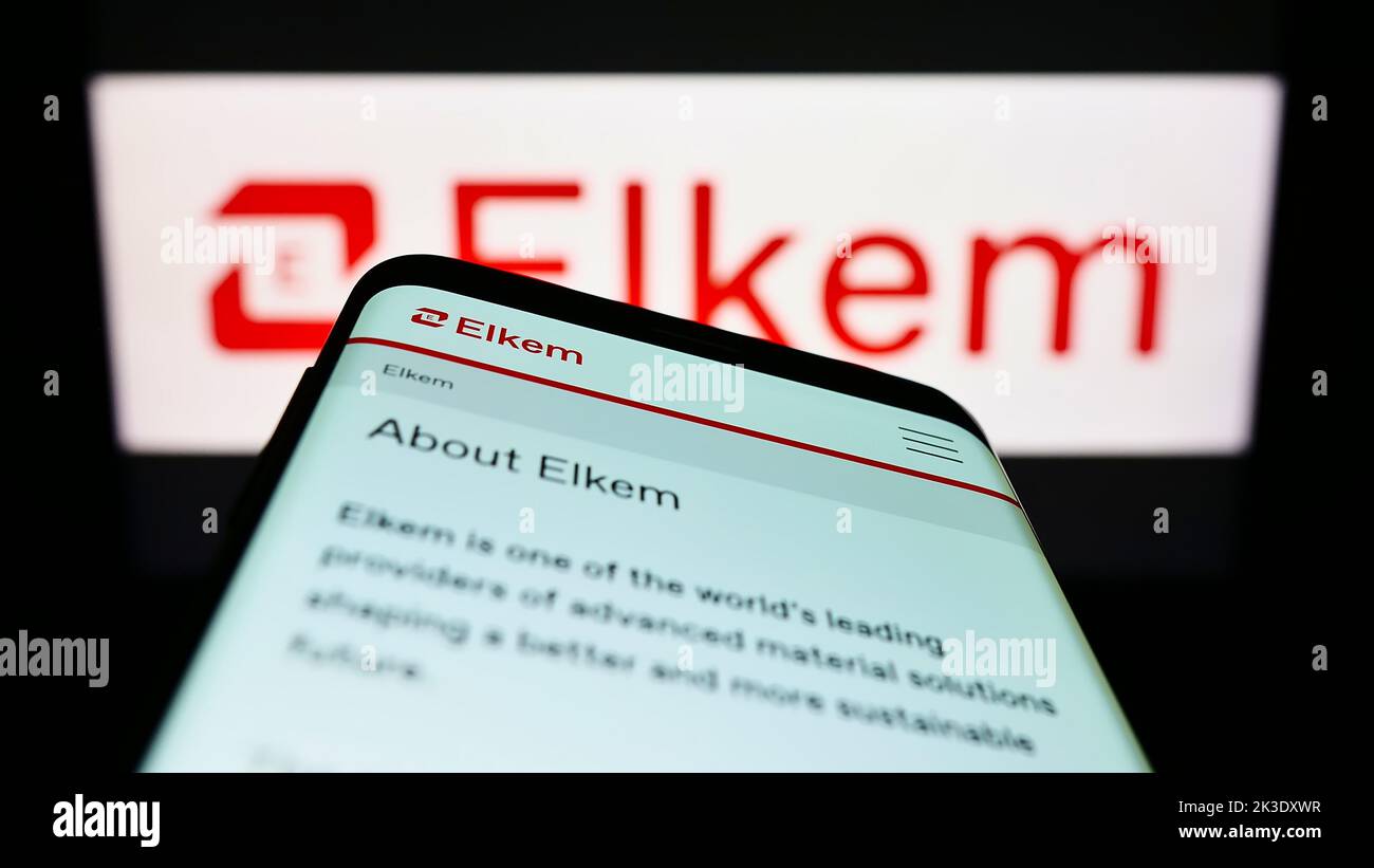 Smartphone avec le site web de la société norvégienne silicones Elkem ASA à l'écran devant le logo de l'entreprise. Faites la mise au point dans le coin supérieur gauche de l'écran du téléphone. Banque D'Images