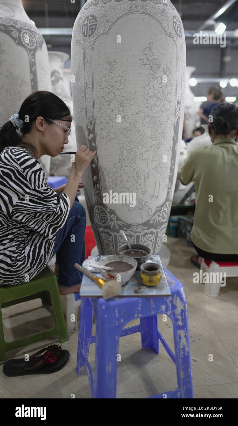 Vietnam, près de Hanoï, céramiste peignant un vase dans une usine de céramique dans le village de céramique de Bat Trang. Banque D'Images