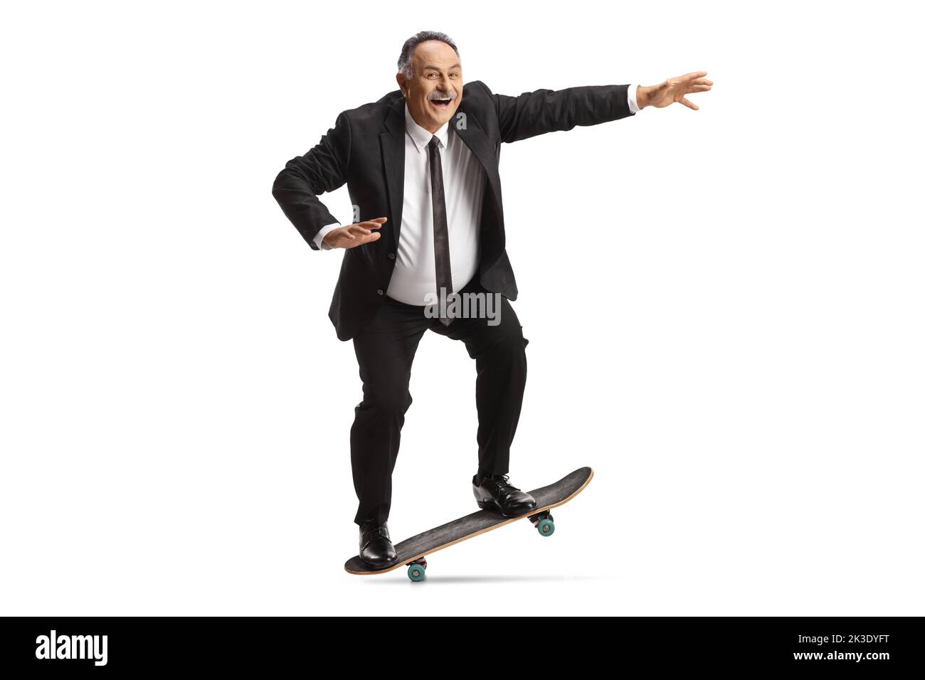 Homme d'affaires mûr à bord d'un skateboard isolé sur fond blanc Banque D'Images