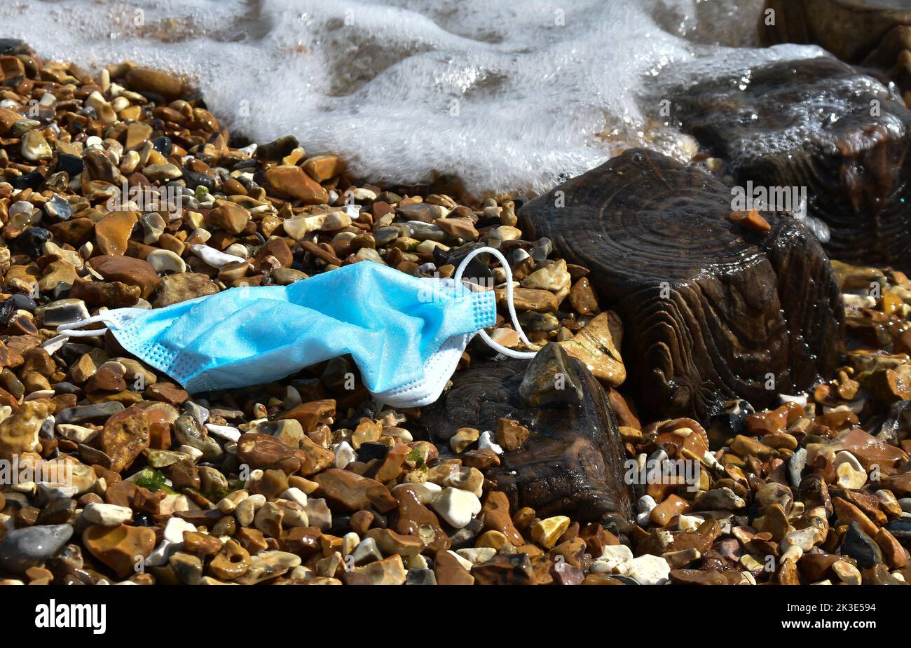 Laissé derrière le masque de papier sur Calshot Beach qui est là depuis longtemps Banque D'Images