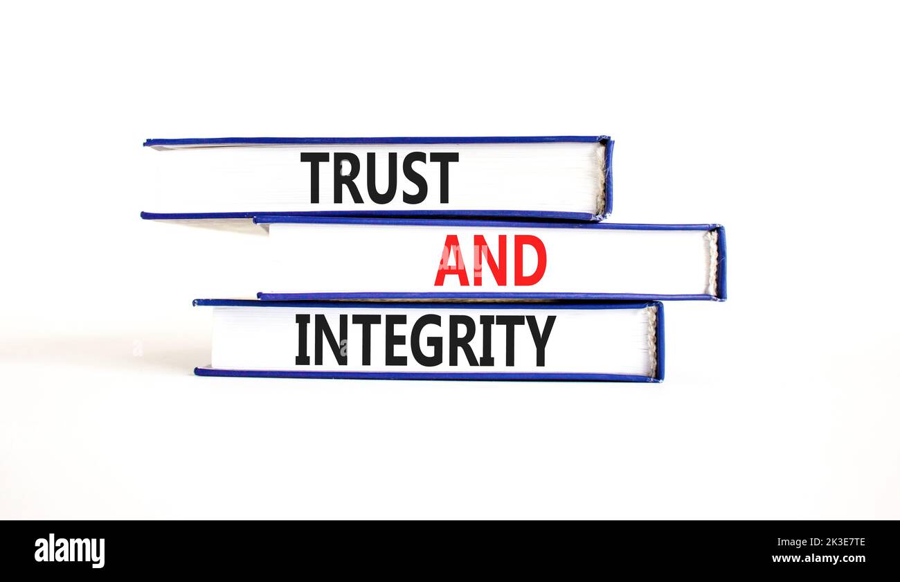 Symbole de confiance et d'intégrité. Mots de concept confiance et intégrité sur les livres. Magnifique table blanche fond blanc. Affaires, psychologique et de confiance et Banque D'Images
