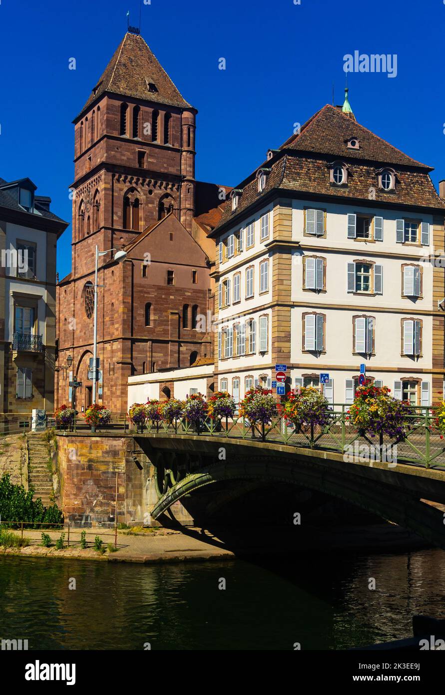 Le paysage urbain de Strasbourg domine l'église Saint-Thomas sur la rive de l'Ill Banque D'Images