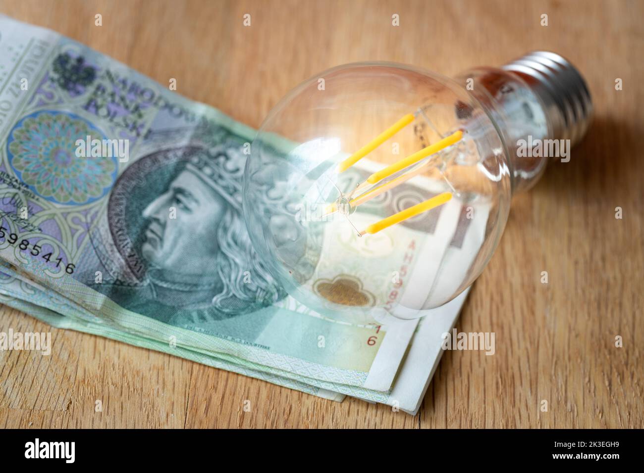 Argent polonais plusieurs centaines de zlotys polonais et une ampoule, le concept de l'augmentation des prix de l'énergie et de l'électricité en Pologne Banque D'Images