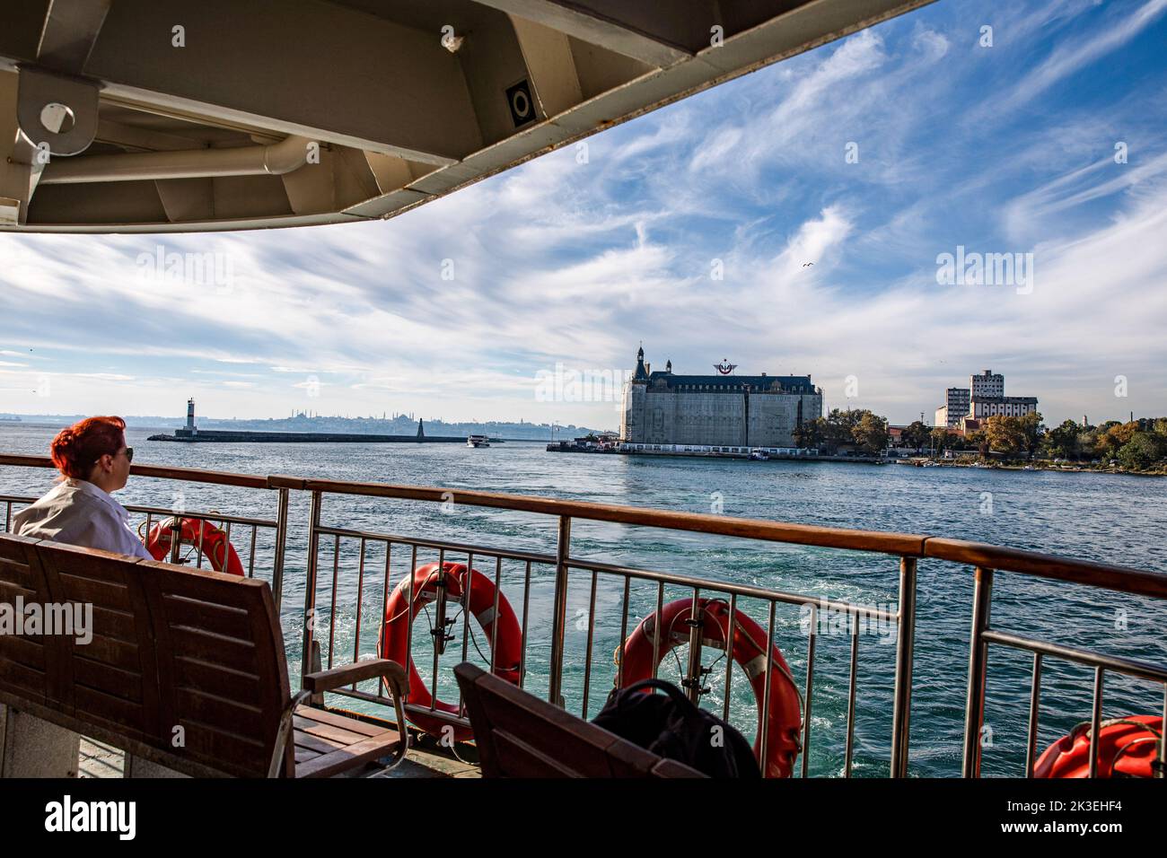 Istanbul, Turquie. 26th septembre 2022. Un passager assis sur les lignes de ferry de la ville qui s'approche de la jetée de Kadikoy et de la gare de Haydarpasa en arrière-plan. Crédit : SOPA Images Limited/Alamy Live News Banque D'Images