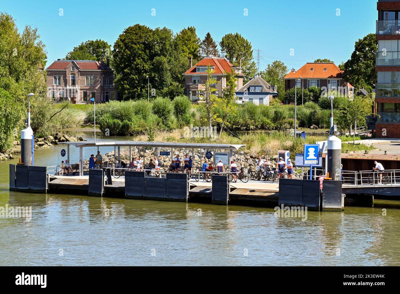 Rotterdam, pays-Bas - août 2022 : les gens et les cyclistes attendent un bateau-taxi à un arrêt de ferry dans une ville de la périphérie de Rotterdam Banque D'Images