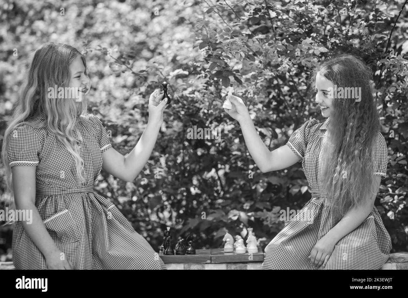 deux adolescentes jouent aux échecs dans une robe rétro en plein air, l'enfance Banque D'Images