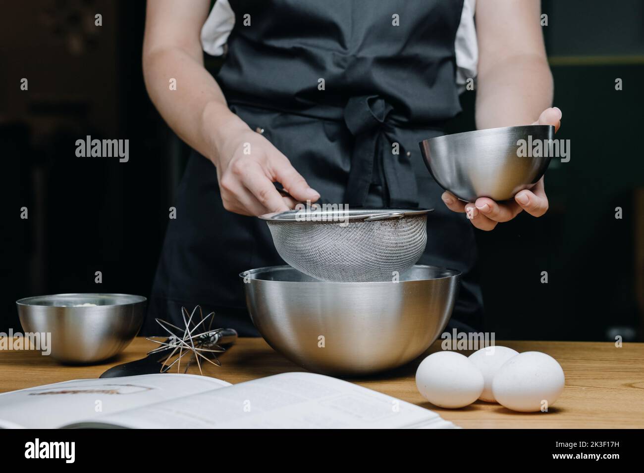 Jeunes femmes tenant une assiette de farine sur un tamis en gros plan. Banque D'Images