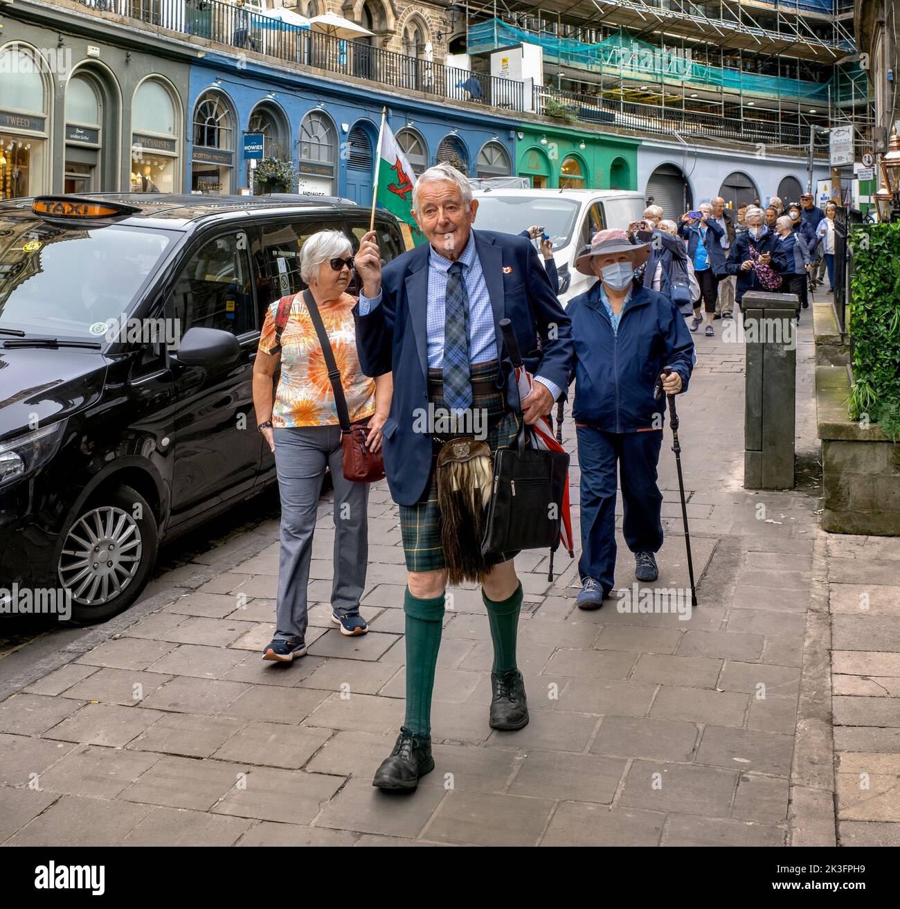 Un guide touristique écossais dirige une partie de touristes dans la rue Victoria, Édimbourg, Royaume-Uni. Banque D'Images
