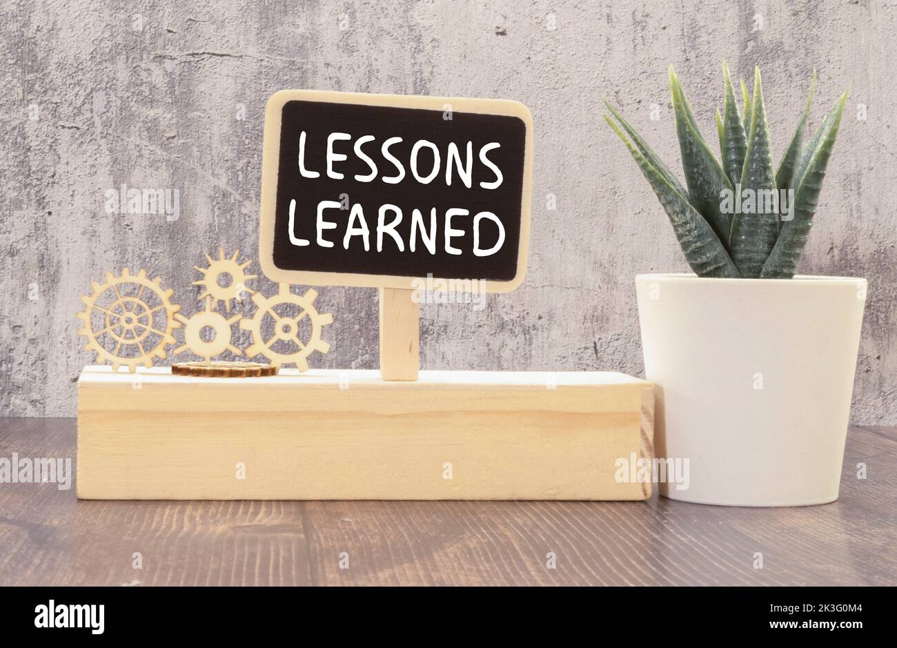 Sur la table se trouvent des crayons de couleur dans un support, des autocollants de couleur vive, des lunettes et un carnet avec les leçons d'inscription APPRISES. Banque D'Images