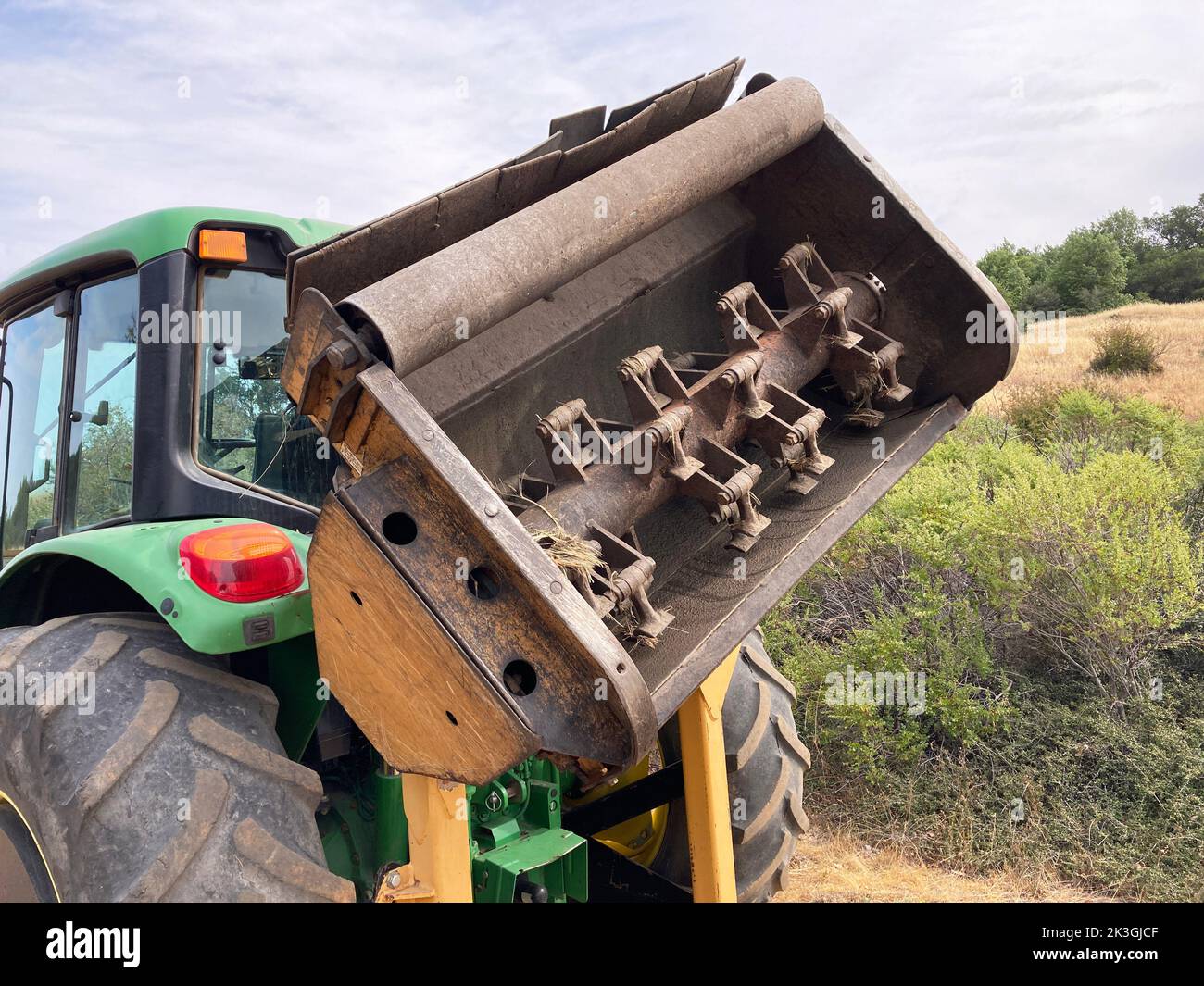 Débroussailleuse forestière fixée au tracteur à roues. Banque D'Images